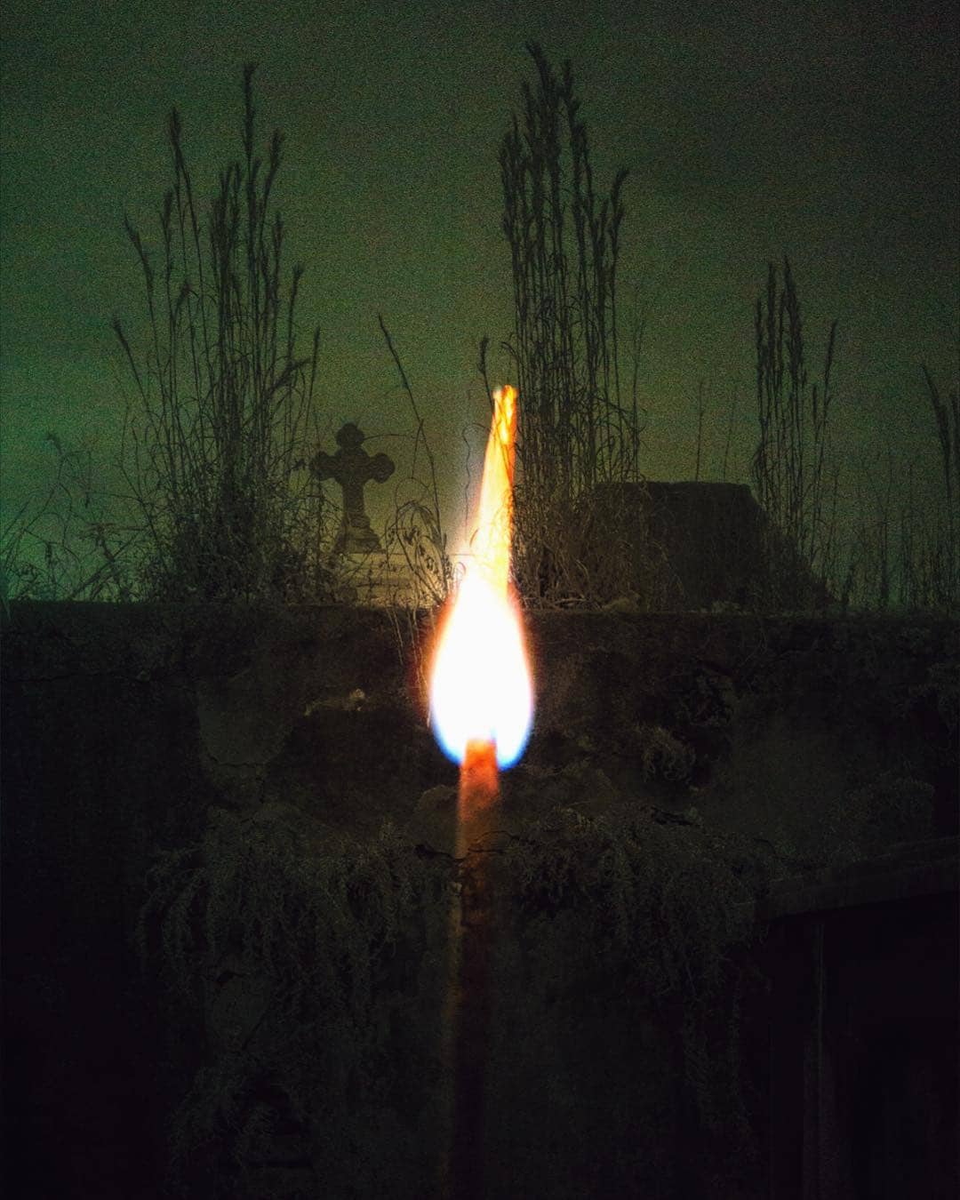 an inscense stick overlayed on a grave